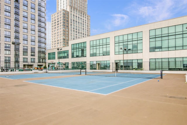 view of tennis court with fence and community basketball court