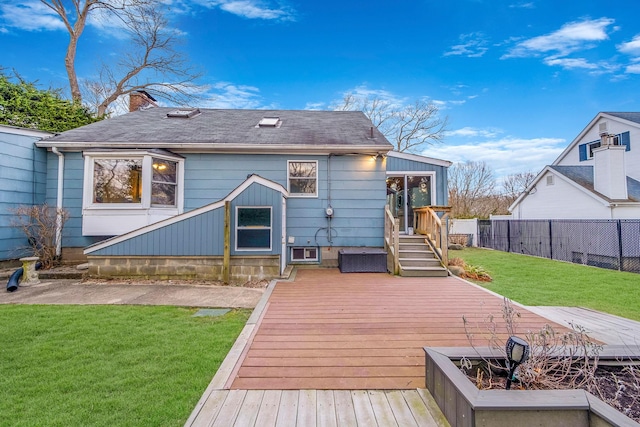 back of property featuring a deck and a lawn