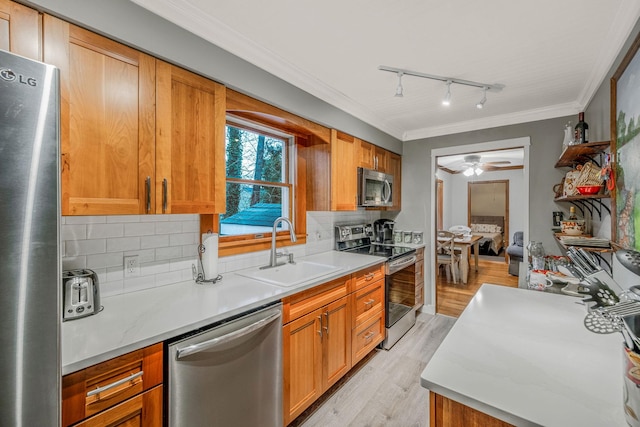 kitchen with appliances with stainless steel finishes, ceiling fan, tasteful backsplash, and sink