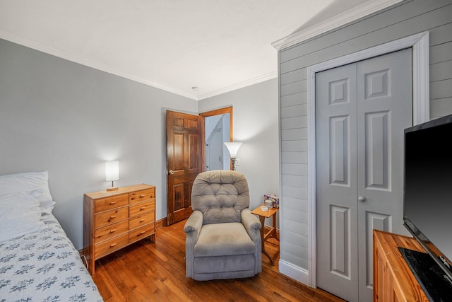 bedroom featuring wood-type flooring, a closet, and ornamental molding