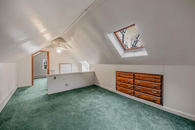 additional living space featuring lofted ceiling with skylight, ceiling fan, a baseboard radiator, and carpet flooring