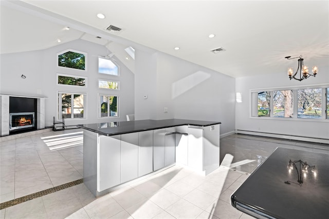 kitchen with a baseboard radiator, pendant lighting, white cabinets, and light tile patterned flooring