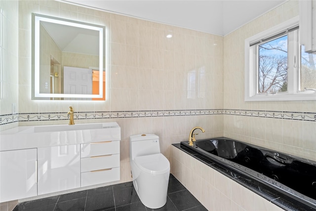 bathroom with tile walls, vanity, tiled bath, tile patterned floors, and toilet