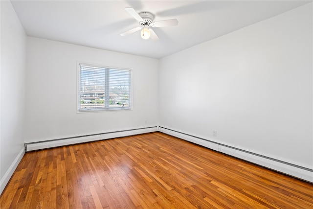 spare room featuring hardwood / wood-style flooring, a baseboard radiator, and ceiling fan