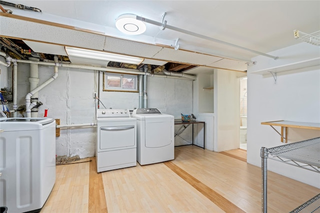 laundry room featuring washer and clothes dryer and light wood-type flooring