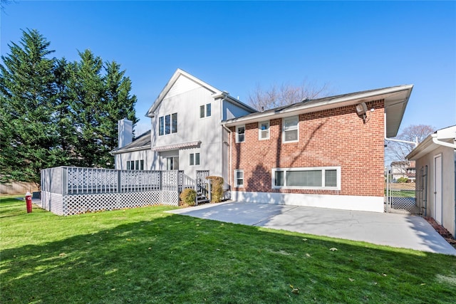 rear view of house with a wooden deck, a yard, and a patio area