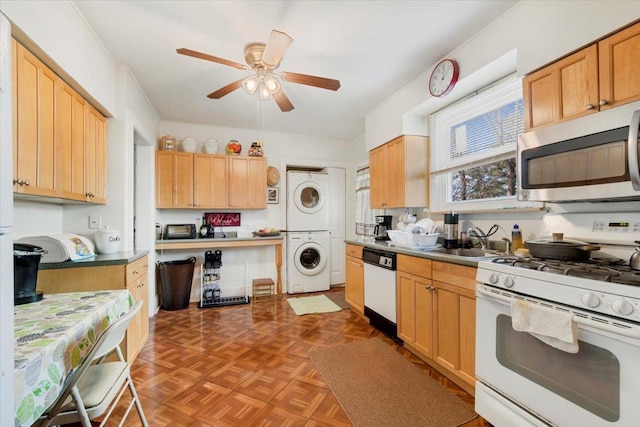 kitchen with stacked washer / dryer, white appliances, light brown cabinetry, sink, and ceiling fan