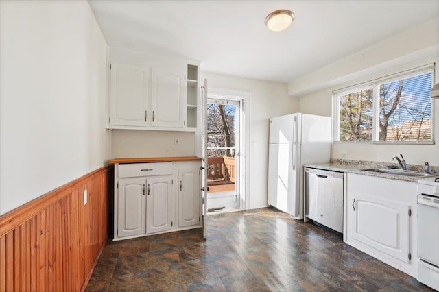 kitchen with white cabinets, plenty of natural light, sink, and white appliances