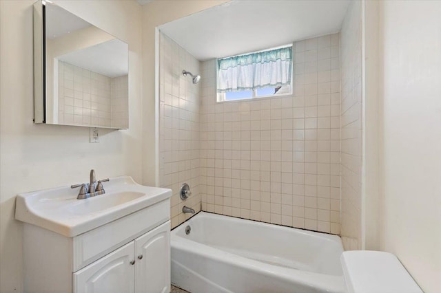 full bathroom with toilet, tiled shower / bath, and vanity