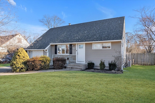 view of front of property featuring a garage, a front lawn, and central AC unit