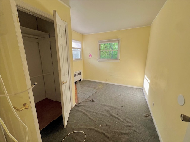 interior space featuring dark carpet and radiator heating unit