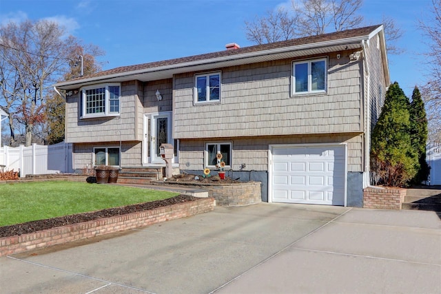 bi-level home featuring a front lawn and a garage