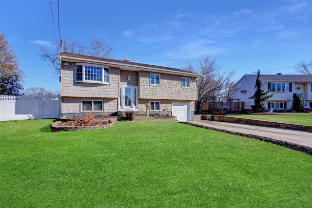 bi-level home with a garage and a front lawn