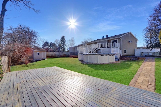 wooden terrace featuring a lawn, a covered pool, and a shed