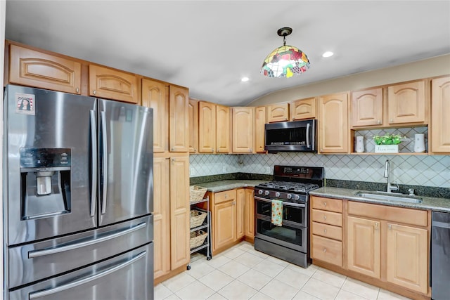 kitchen featuring stainless steel appliances, dark stone countertops, sink, and light brown cabinetry