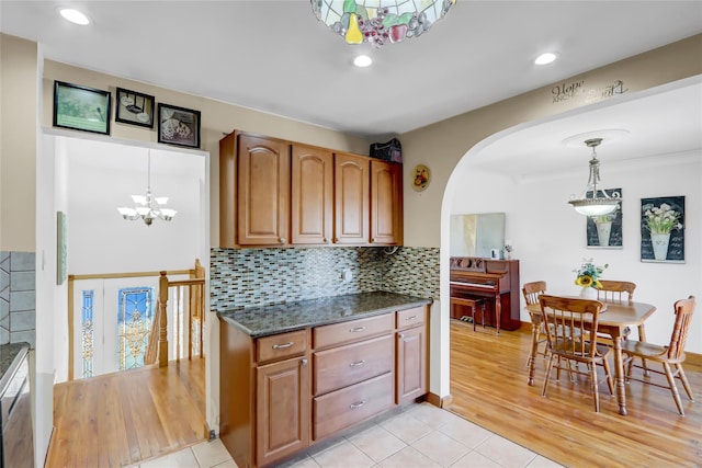 kitchen with hanging light fixtures, a chandelier, light tile patterned flooring, and tasteful backsplash