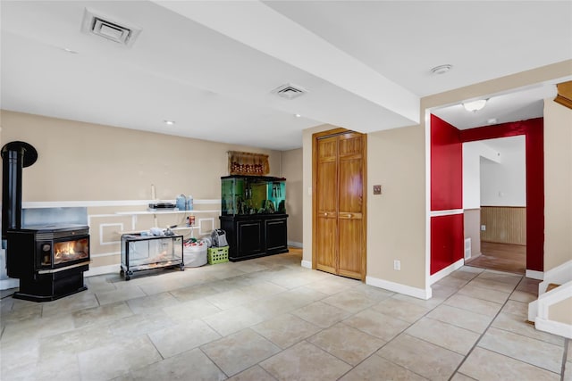 unfurnished living room with wood walls and a wood stove