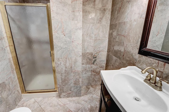 bathroom featuring tile walls, a shower with door, and vanity