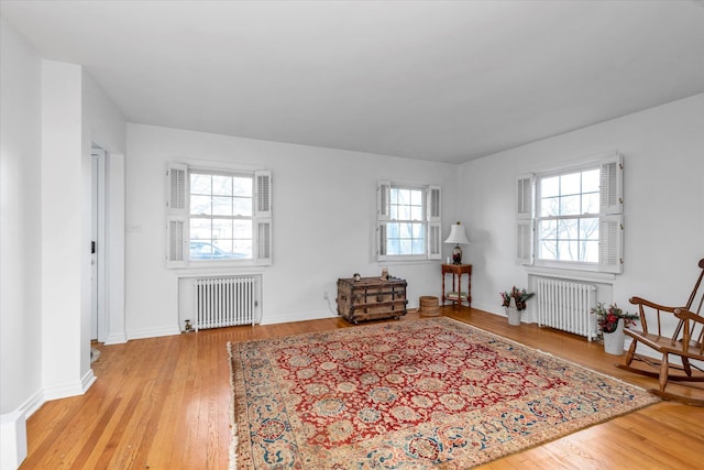 sitting room with light hardwood / wood-style floors, plenty of natural light, and radiator