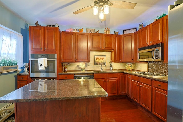 kitchen featuring dark hardwood / wood-style flooring, sink, appliances with stainless steel finishes, tasteful backsplash, and a center island