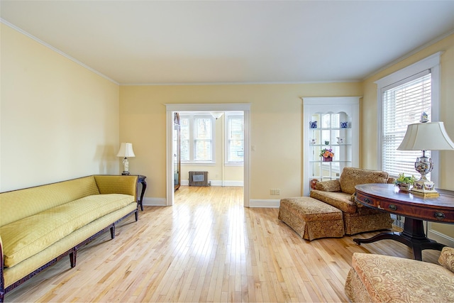 sitting room with ornamental molding, light hardwood / wood-style floors, and radiator heating unit