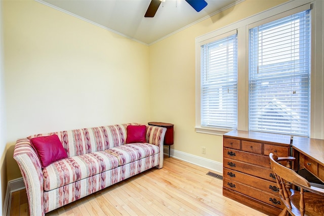 living room with crown molding, ceiling fan, and light hardwood / wood-style flooring