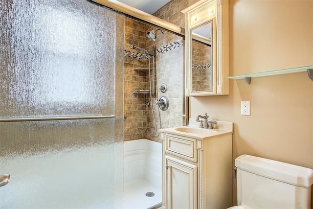 bathroom with vanity, a shower with shower door, and toilet