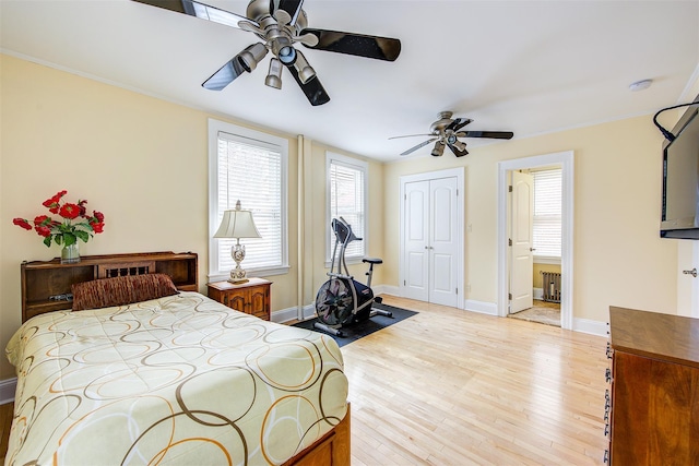 bedroom with radiator, ceiling fan, light hardwood / wood-style flooring, and a closet