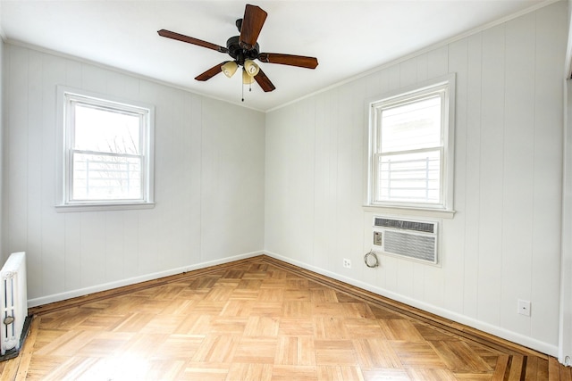 unfurnished room with light parquet floors, crown molding, ceiling fan, a wall mounted air conditioner, and radiator heating unit