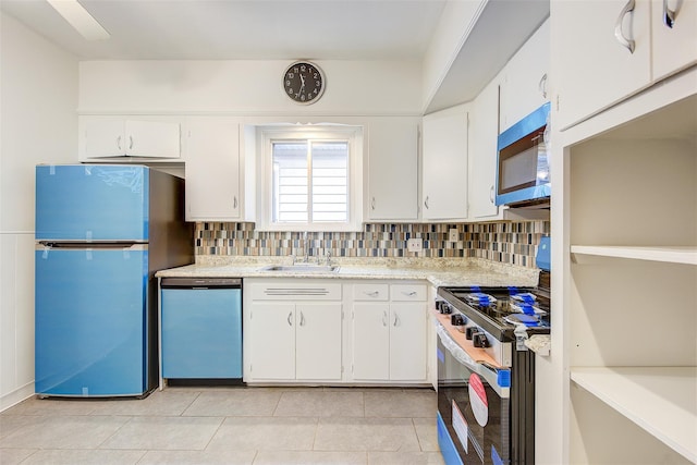 kitchen featuring refrigerator, dishwashing machine, stainless steel range, white cabinetry, and sink