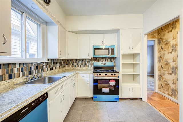 kitchen featuring white cabinets, stainless steel appliances, light tile patterned floors, decorative backsplash, and sink