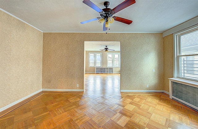 empty room featuring light parquet flooring, a textured ceiling, ceiling fan, and crown molding