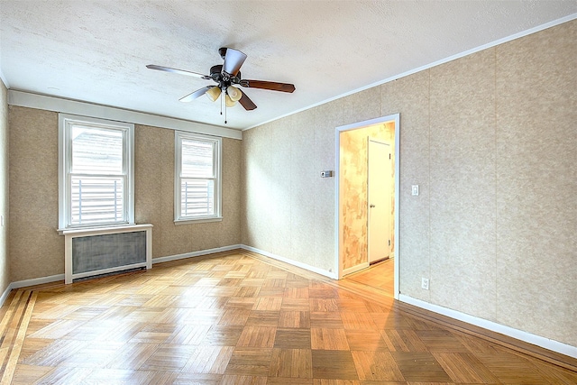 spare room featuring a textured ceiling, light parquet flooring, radiator, ornamental molding, and ceiling fan