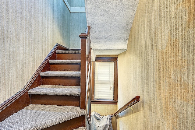 stairs with a textured ceiling