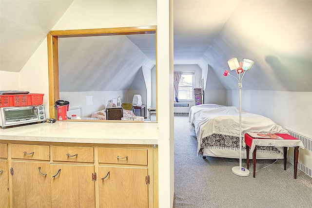 carpeted bedroom featuring lofted ceiling and radiator