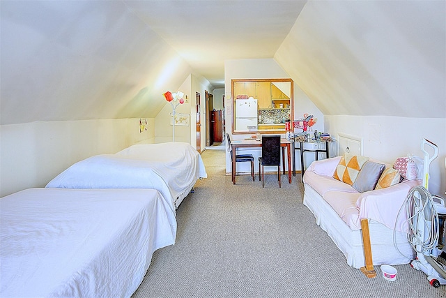 bedroom with white refrigerator, vaulted ceiling, and light colored carpet