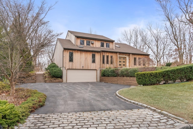 view of front of home with a front yard and a garage