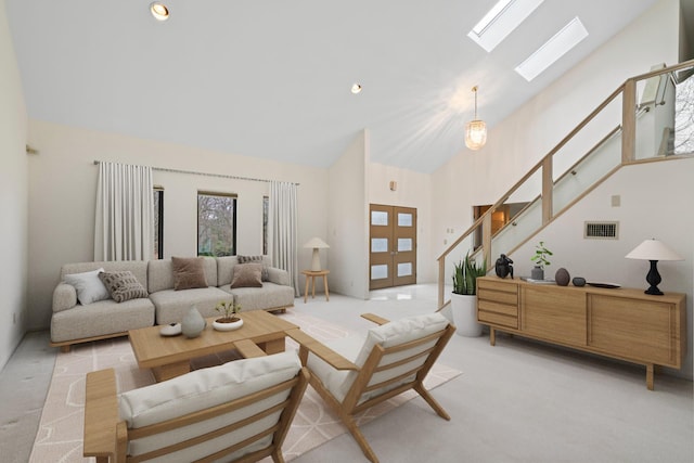 carpeted living room with a skylight and high vaulted ceiling