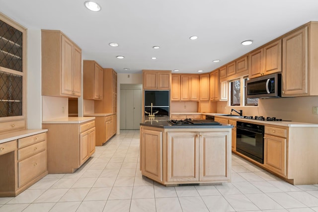 kitchen featuring a kitchen island, light brown cabinetry, and black appliances