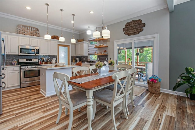 dining room featuring ornamental molding and light hardwood / wood-style floors