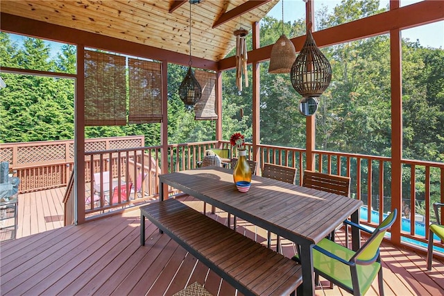 sunroom / solarium featuring ceiling fan, wood ceiling, a healthy amount of sunlight, and lofted ceiling