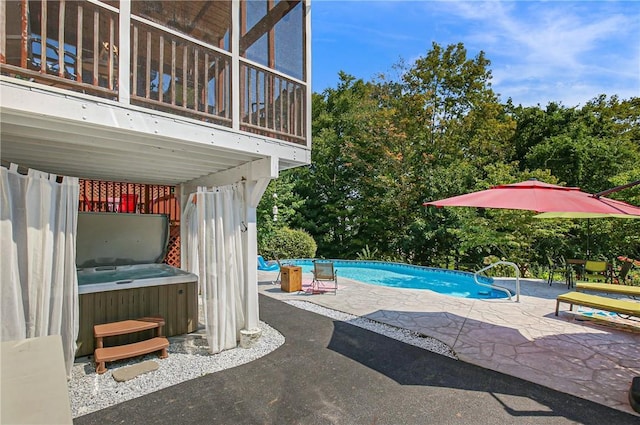 view of swimming pool with a hot tub and a patio