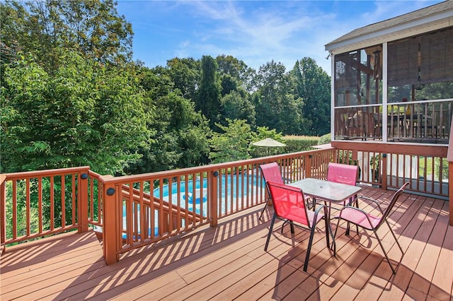 wooden terrace featuring a pool and a sunroom