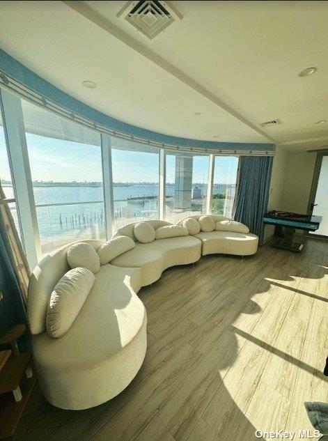 living room featuring hardwood / wood-style floors and a water view