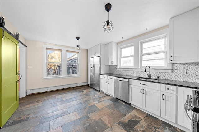 kitchen featuring stainless steel appliances, a barn door, white cabinets, a baseboard radiator, and sink