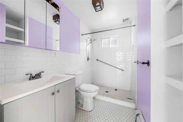 bathroom featuring tile patterned flooring, toilet, a tile shower, vanity, and baseboard heating