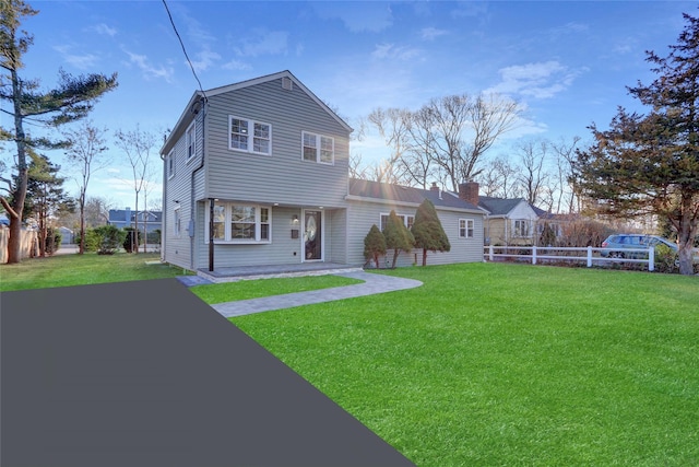 rear view of property with a lawn