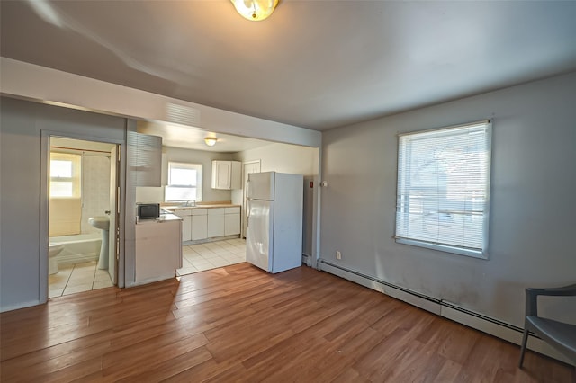 interior space featuring a baseboard heating unit, light hardwood / wood-style floors, and sink