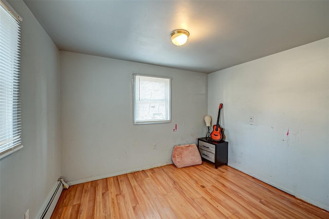 spare room with a baseboard radiator and wood-type flooring