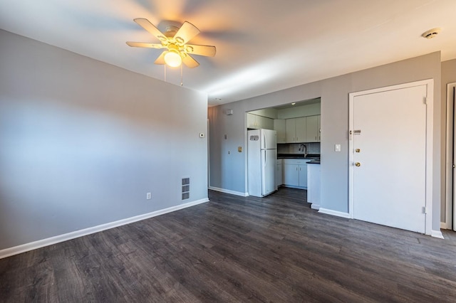 unfurnished living room with sink, ceiling fan, and dark wood-type flooring